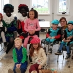 Kinderen op de foto met twee zwarte pieten