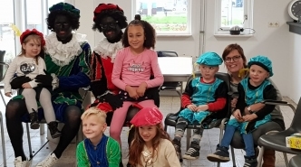 Kinderen op de foto met twee zwarte pieten