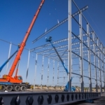 Bouw van staalconstructie met kraan en twee hoogwerkers